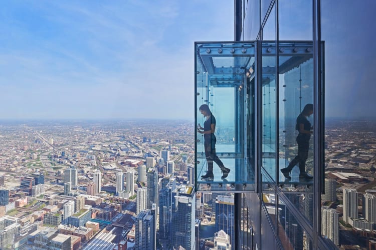 A person in a glass box on an observation tower