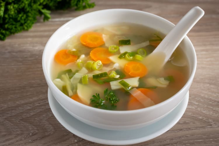 Vegetable stock broth using fresh carrots, leeks and onions