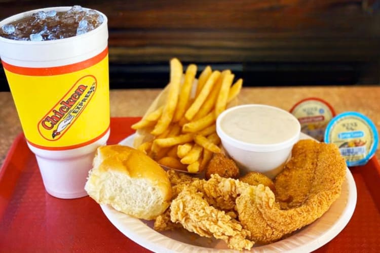 Fried fish and chicken tenders with a bread roll, fries and gravy