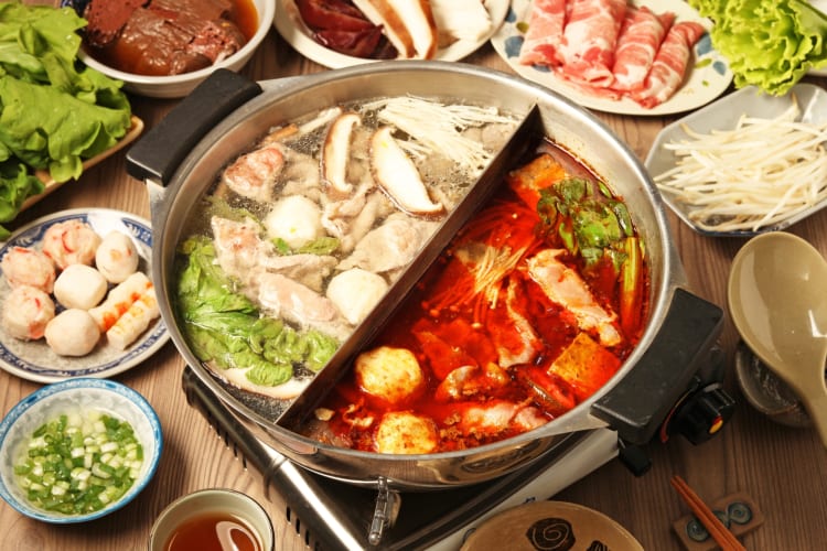 A hot pot dish surrounded by ingredients