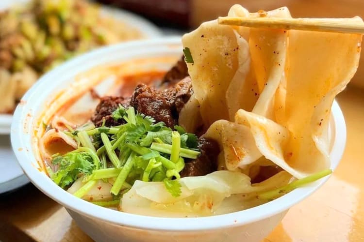 A noodle dish with meat and green onions