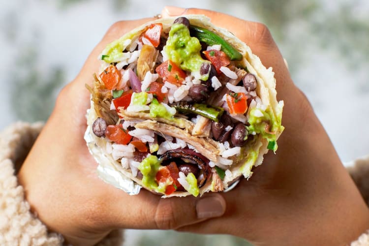 A person holding a burrito