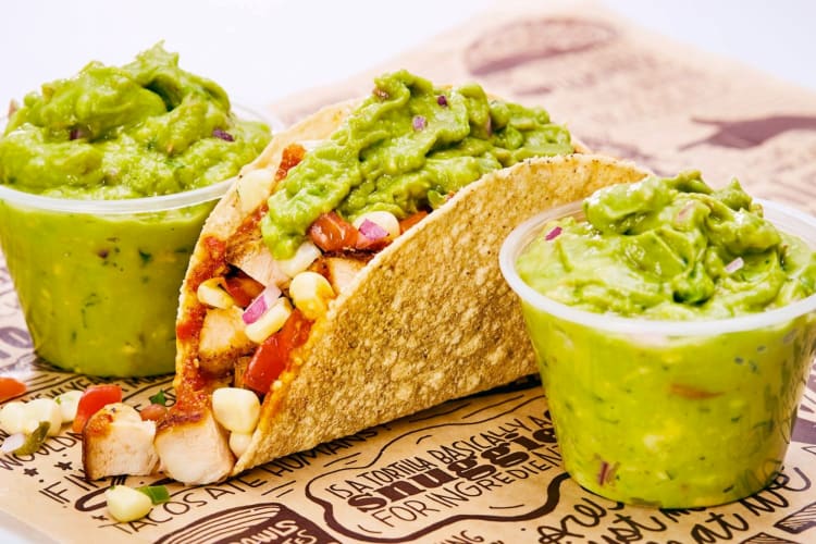 A single taco from Chipotle next to containers of guacamole