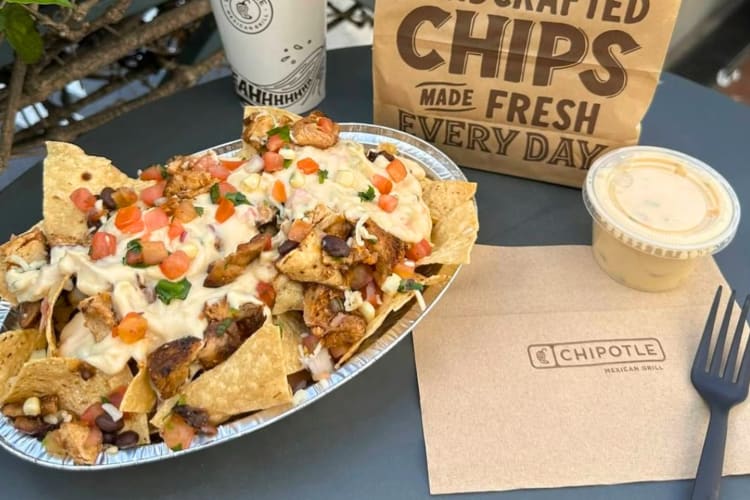 Nachos, a drink, a take-out bag and queso from Chipotle