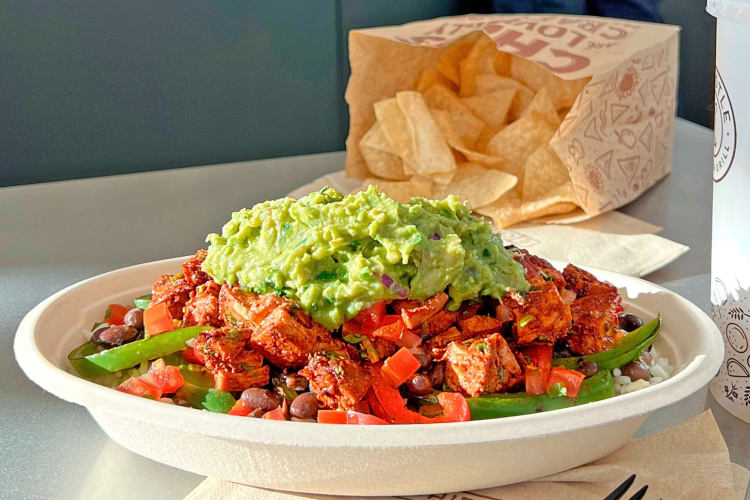 Burrito bowl in front of a bag of chips, from Chipotle
