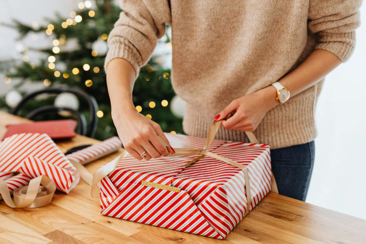 A person wrapping a Christmas present