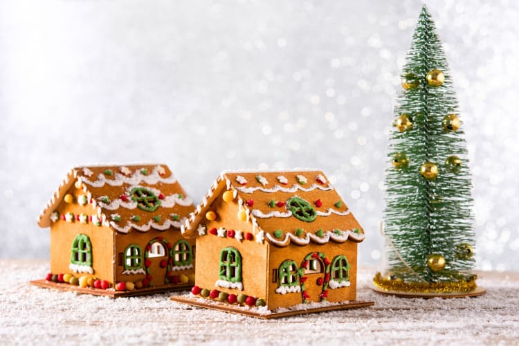 Two gingerbread houses next to a small Christmas tree decoration