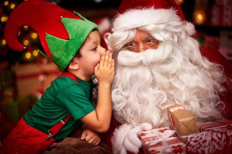 A kid dressed as an elf with Santa