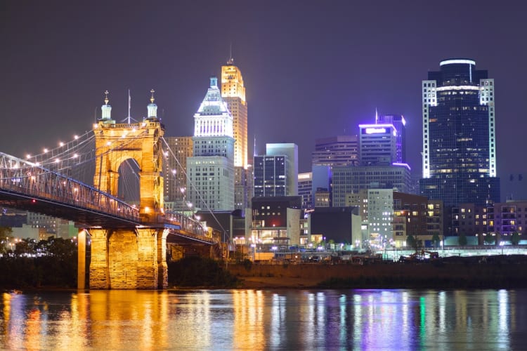 A city skyline illuminated at night next to a river