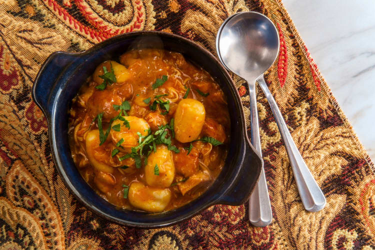 A bowl of chicken stew with gnocchi