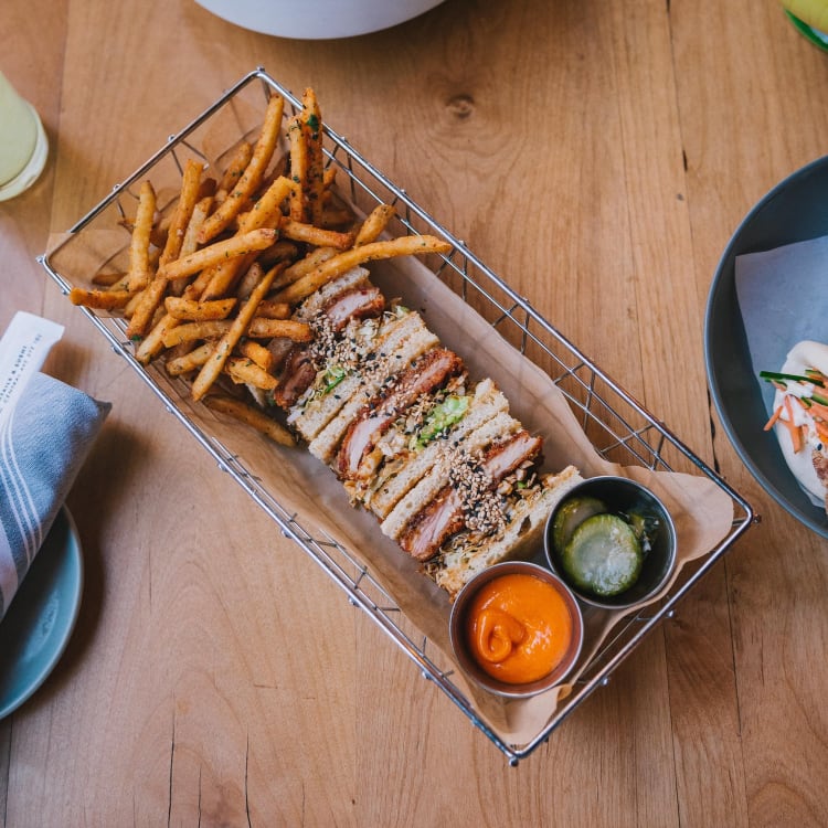 Sandwich and chips with sauces in a basket from the restaurant Clever Koi