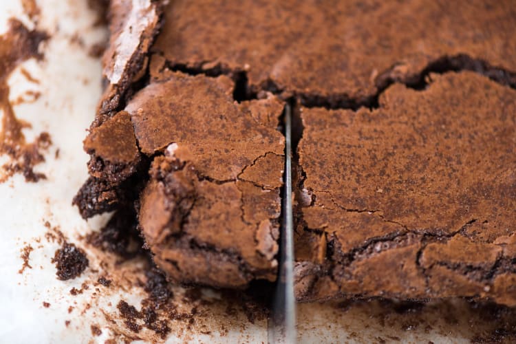 Close-up of a brownie with a flaky texture being sliced