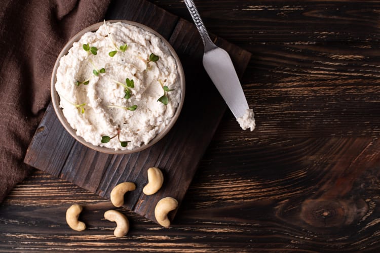 Cashew cream in a bowl next to whole cashews