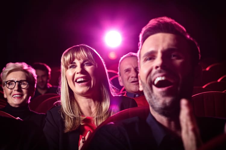 Close-up of faces in a crowd laughing during a show