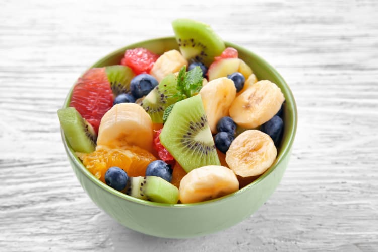 Bowl of fruit with bananas, blueberries, kiwi and other fruits