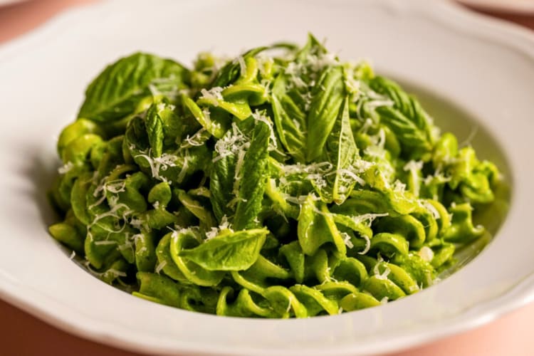 Green pasta dish topped with leaves and grated cheese from Contessa, a restaurant in Boston