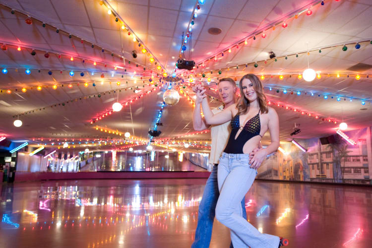 Couple roller skating together in an arena as a fun birthday idea in Cincinnati for adults