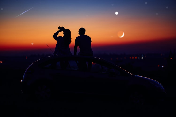 Couple sitting on a car while stargazing for a date idea in OKC