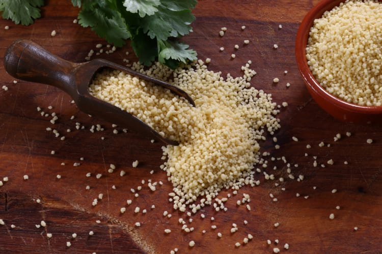 Dried couscous in a bowl and a spoon