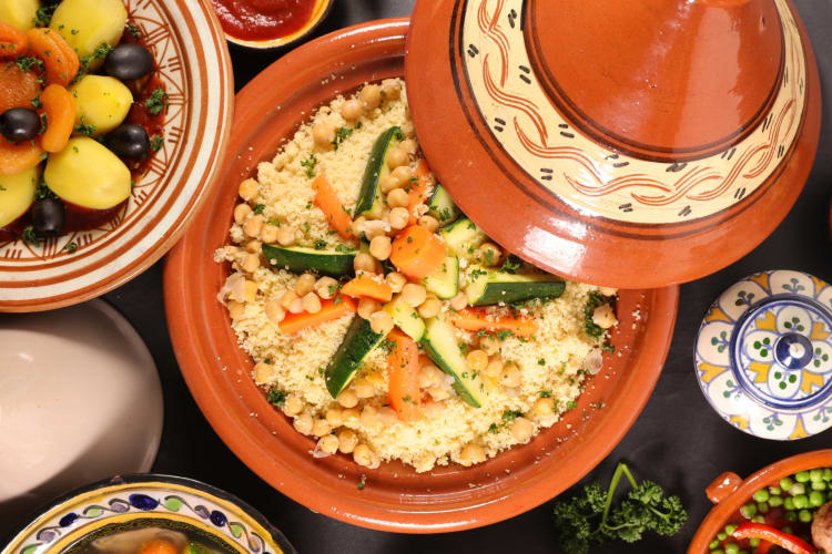 A couscous dish in a tagine next to other dishes