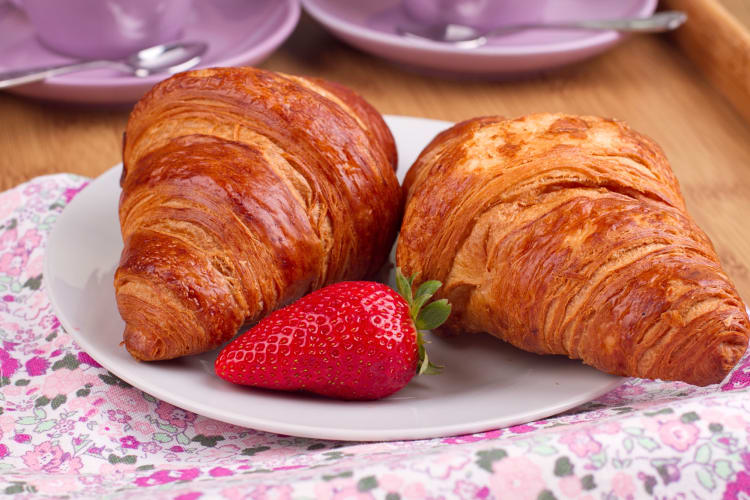 Two strawberry croissants served with a strawberry