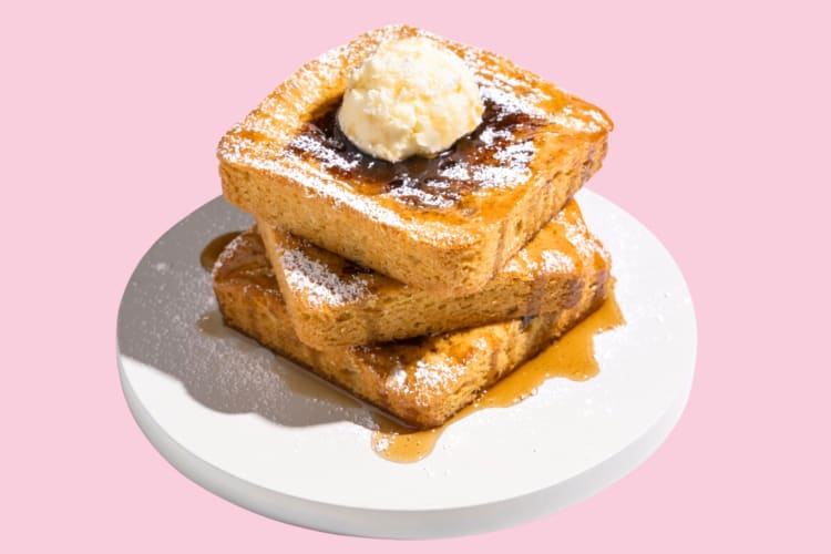 French toast cookies with frosting on a pink background