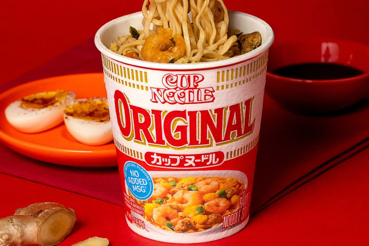 An Original Cup Noodle on a red surface