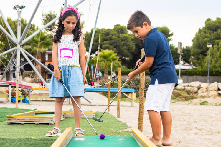 Two kids playing mini golf