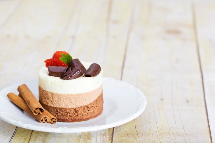 Chocolate mousse dessert portion with cinnamon sticks on the side