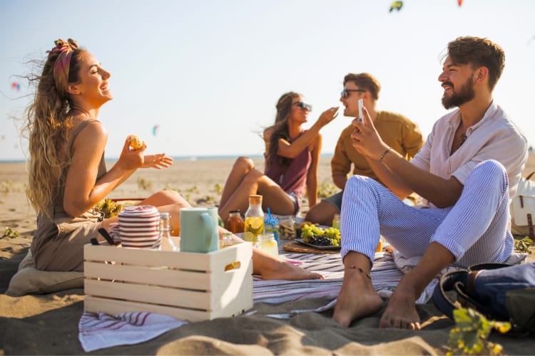 Two couples having a picnic on the beach