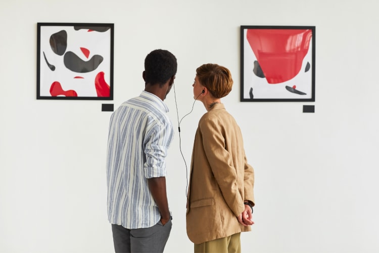 Two people looking at artworks in a gallery