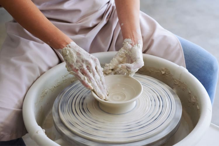 A person crafting pottery on a pottery wheel