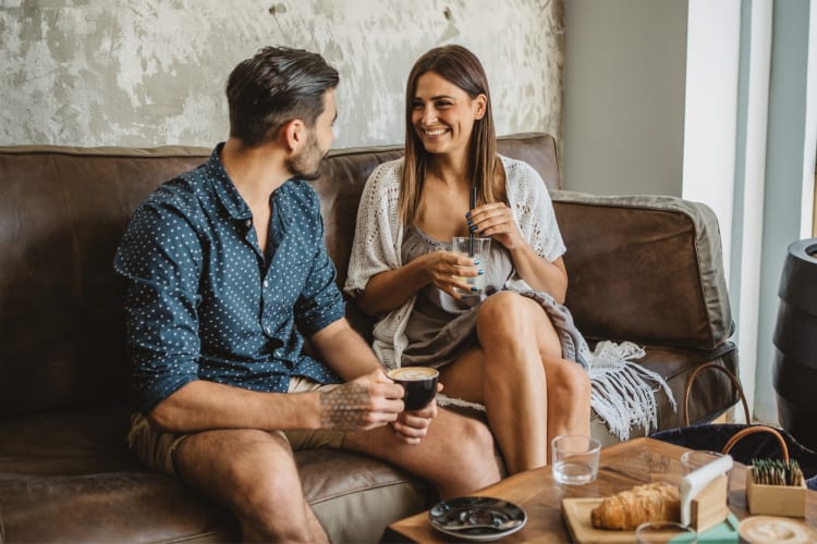 A couple sitting on a couch in a coffee shop