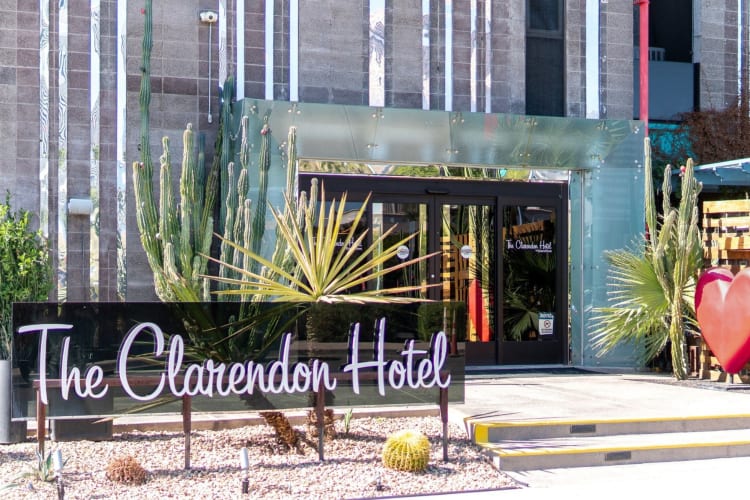 A hotel entrance with a sign that says The Clarendon Hotel