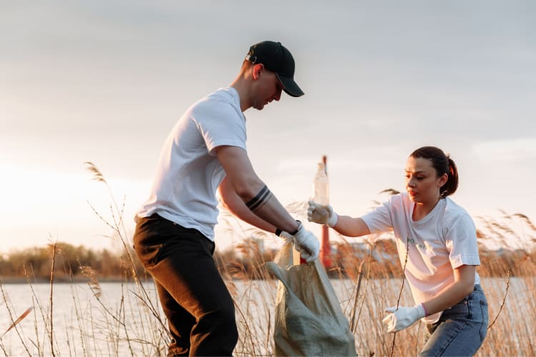 A couple volunteering and picking up trash together 