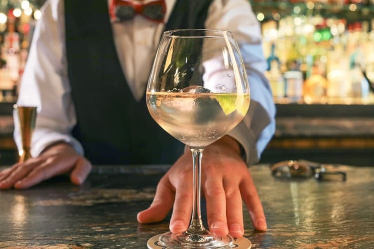 A bartender and a freshly made cocktail