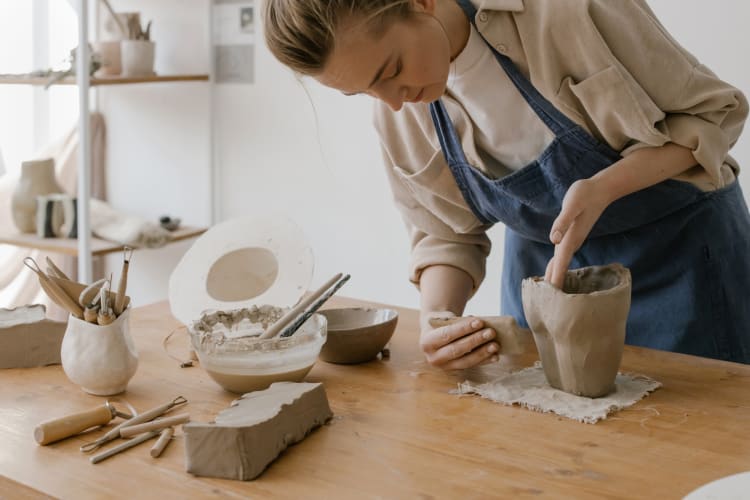 A woman shaping a pottery pot