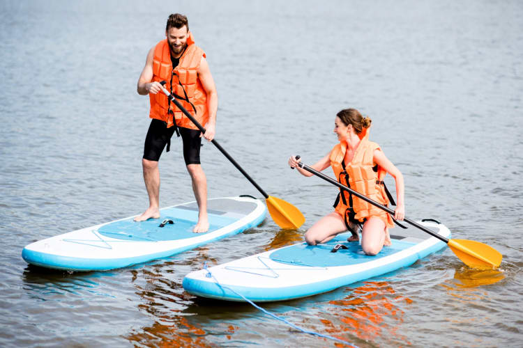 Two people paddleboarding on a river