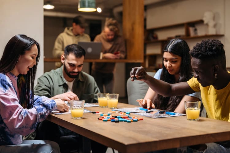 Four people playing a board game