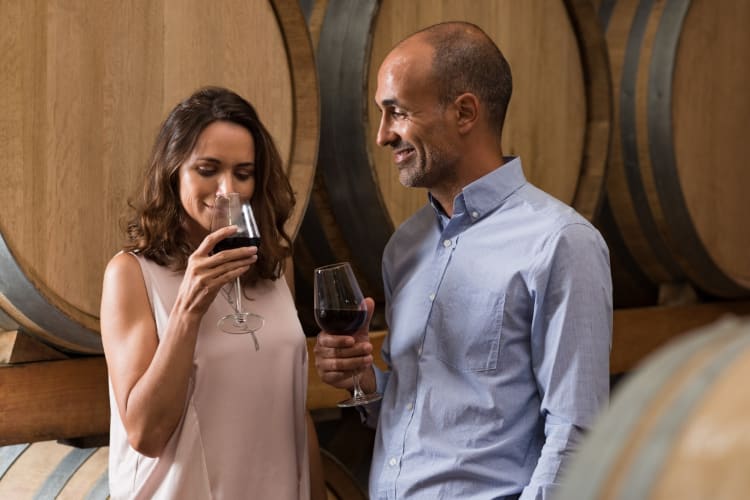 A couple drinking wine in a wine cellar