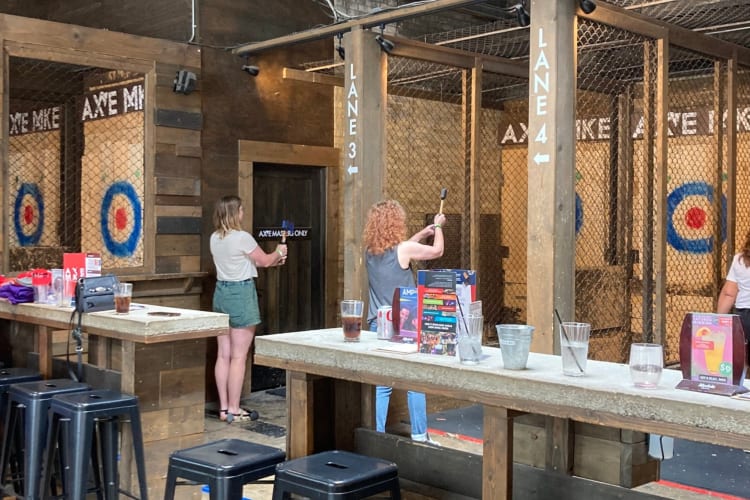 People throwing axes at an axe throwing venue