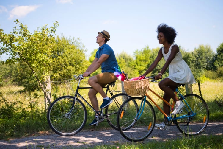 A couple biking on a path next to greenery