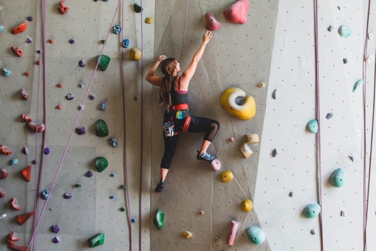 A woman climbing on an indoor rock wall