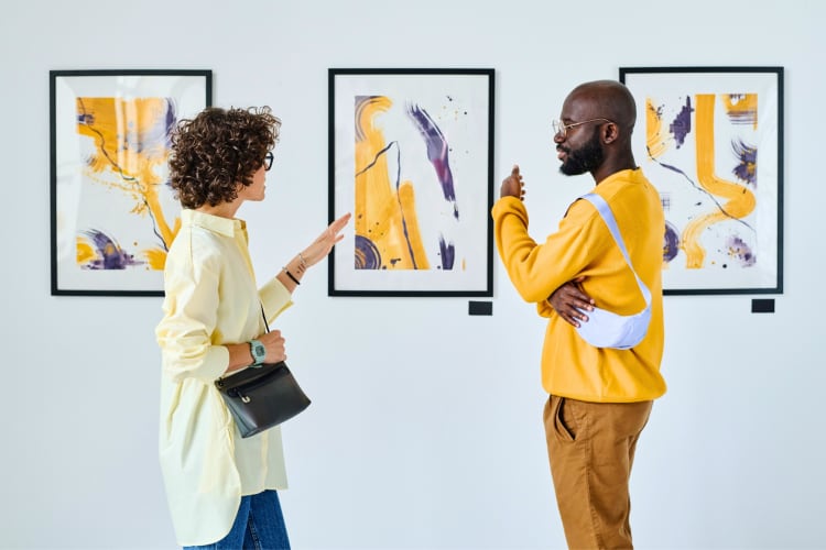 A couple in an art gallery looking at paintings