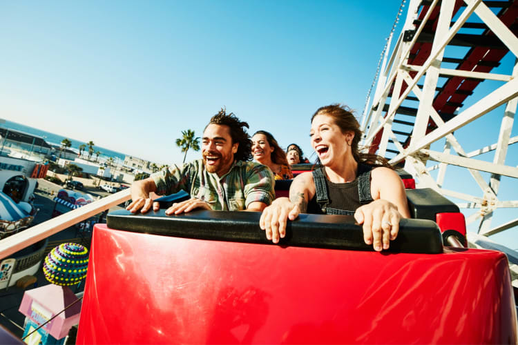 A couple riding a roller coaster at a theme park