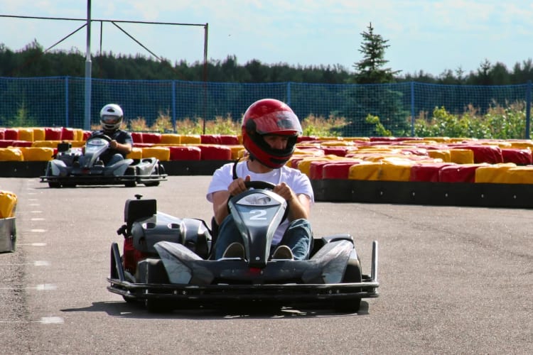 Two people go-karting on an outdoor track