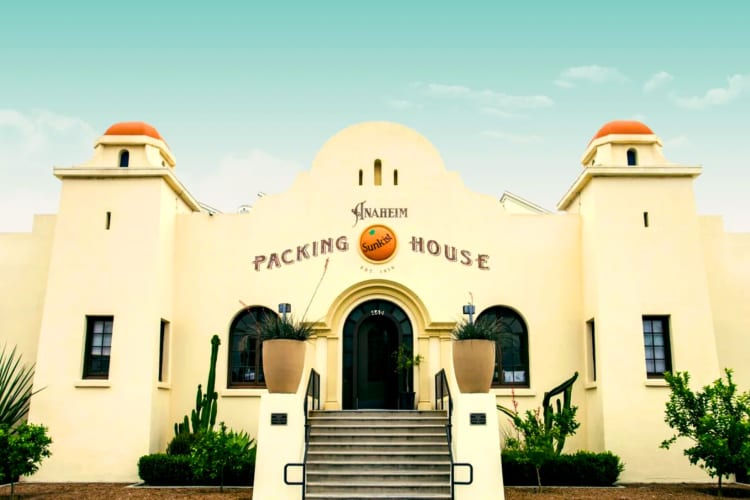 A large cream building with two towers and an Anaheim Packing House sign