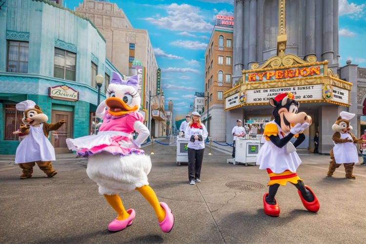 Disney characters dancing in an outdoor show