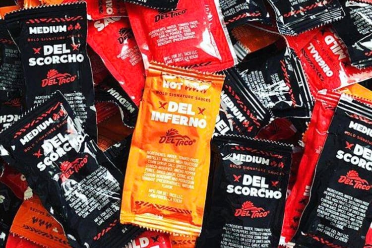 A selection of Del Taco hot sauce packets