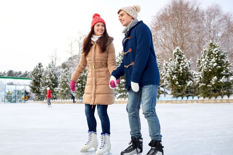 A couple ice skating on an outdoor rink